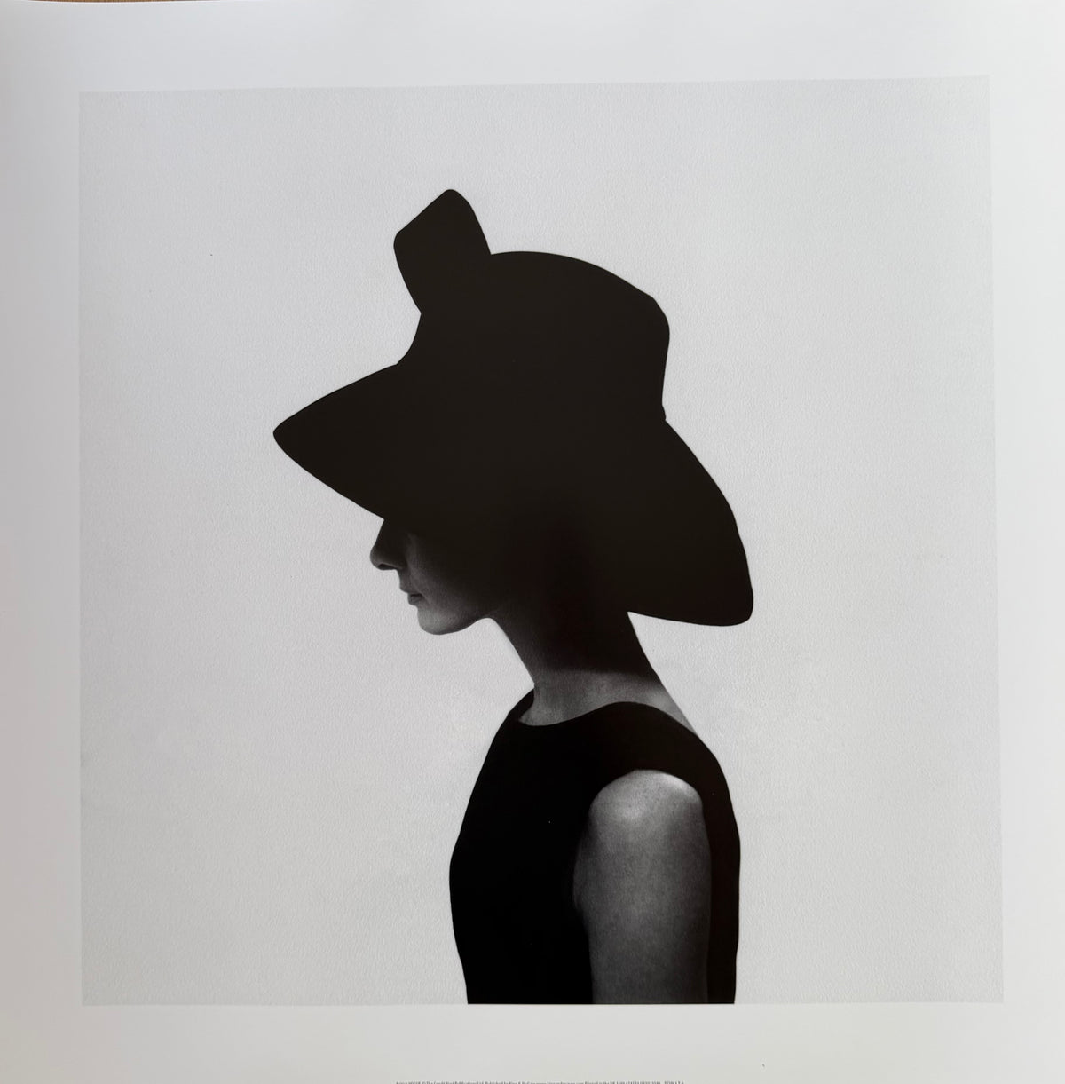 Cecil Beaton, Audrey Hepburn wearing a Givenchy hat, photo art print: a black-and-white profile photograph of a woman in a wide-brimmed black hat and a sleeveless black dress.